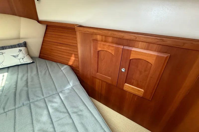 Tova Yacht Photos Pics Cozy cabin interior of 2007 Legacy Yachts 32 Sedan with wooden paneling and bed.