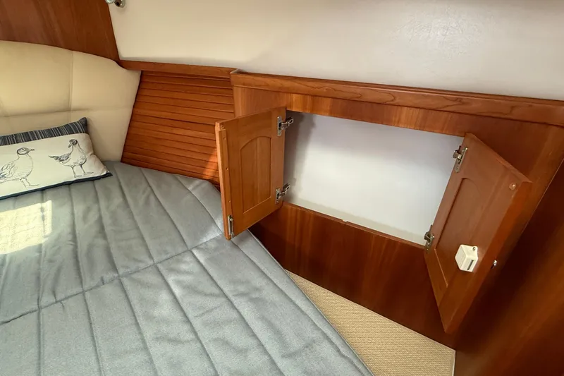 Tova Yacht Photos Pics Cozy cabin interior of 2007 Legacy Yachts 32 Sedan with wooden storage and bedding.