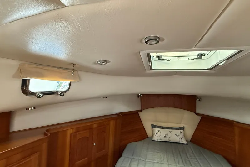 Tova Yacht Photos Pics Cozy cabin interior of 2007 Legacy Yachts 32 Sedan with skylight and wooden accents.