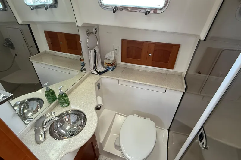 Tova Yacht Photos Pics 2007 Legacy Yachts 32 Sedan bathroom with sink, toilet, and storage cabinets.