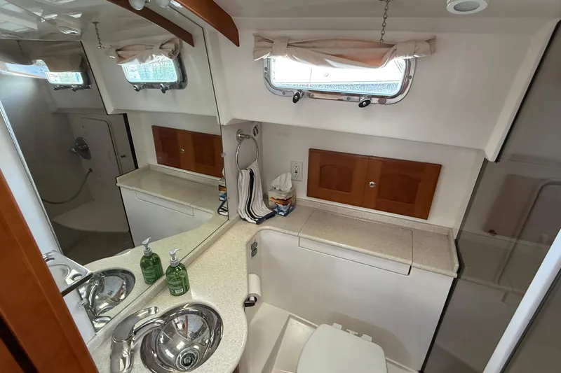 Tova Yacht Photos Pics Bathroom interior of 2007 Legacy Yachts 32 Sedan with sink, mirror, and storage.