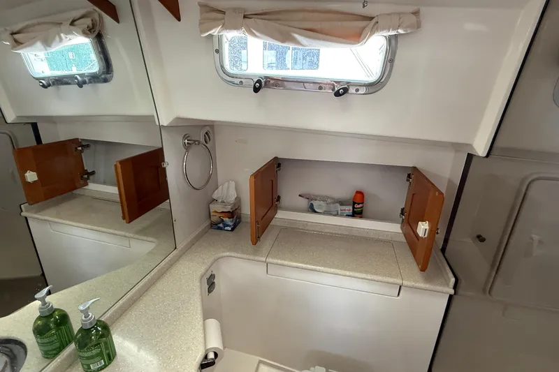 Tova Yacht Photos Pics 2007 Legacy Yachts 32 Sedan bathroom with sink, mirror, and storage cabinets.