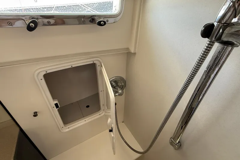 Tova Yacht Photos Pics Shower area in 2007 Legacy Yachts 32 Sedan with storage compartment and chrome fixtures.