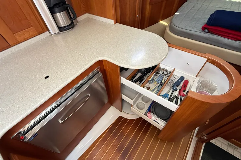 Tova Yacht Photos Pics 2007 Legacy Yachts 32 Sedan galley with open drawer, utensils, and countertop.