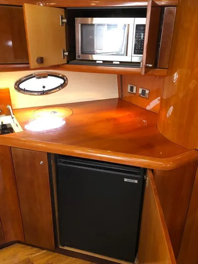 Hotan Yacht Photos Pics 2003 Sunseeker Portofino 46 yacht kitchen with microwave, fridge, and wooden cabinetry.