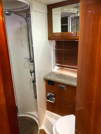 Hotan Yacht Photos Pics Bathroom interior of 2003 Sunseeker Portofino 46 yacht with shower and wooden cabinetry.