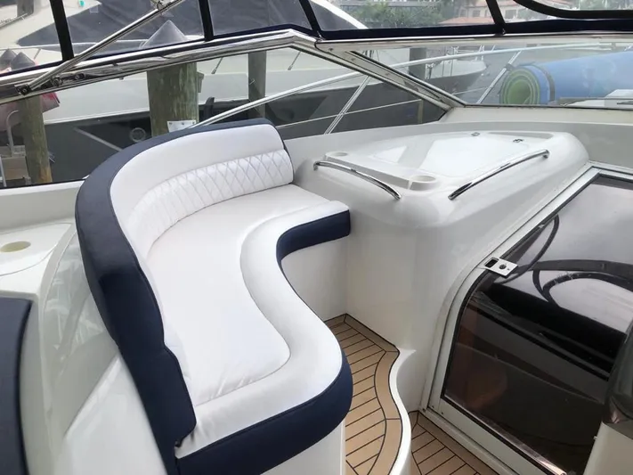 Hotan Yacht Photos Pics Luxurious seating area on a 2003 Sunseeker Portofino 46 yacht, featuring elegant white and navy upholstery.