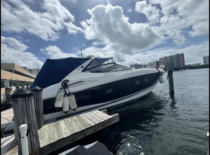 Hotan Yacht Photos Pics 2003 Sunseeker Portofino 46 yacht docked under a partly cloudy sky.