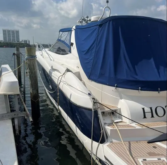 Hotan Yacht Photos Pics 2003 Sunseeker Portofino 46 yacht docked, featuring blue covers and sleek design.