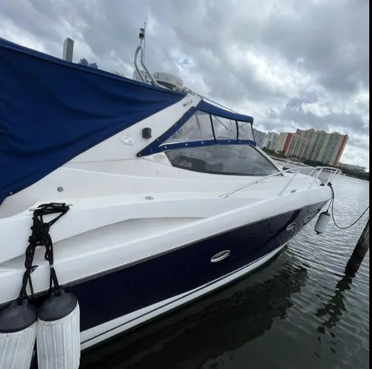 Hotan Yacht Photos Pics 2003 Sunseeker Portofino 46 yacht docked, featuring sleek design and blue canopy.