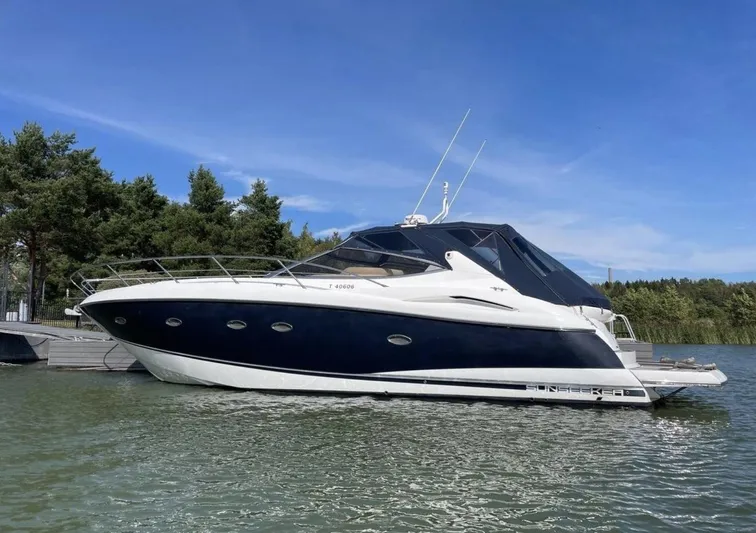 Hotan Yacht Photos Pics 2003 Sunseeker Portofino 46 yacht docked on a sunny day, surrounded by trees.