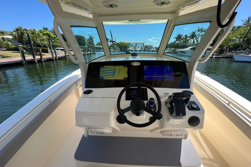  Yacht Photos Pics 2024 Scout 355 LXF boat helm with dual screens and waterfront view.