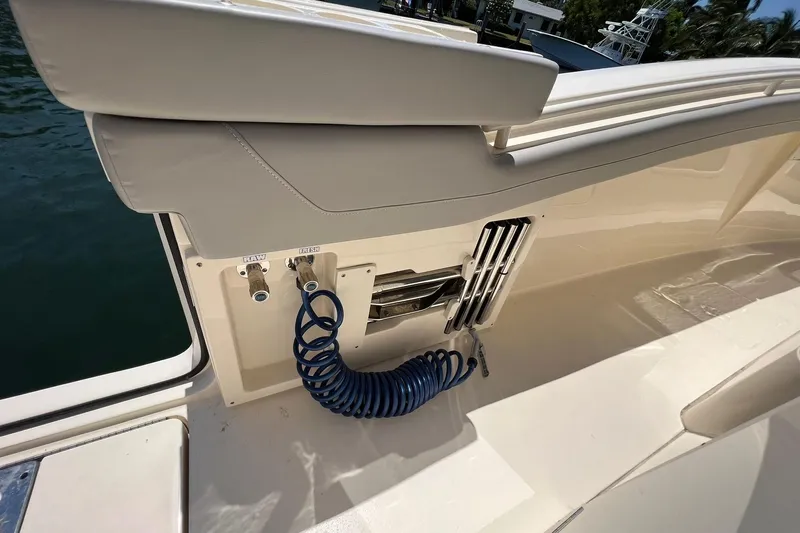  Yacht Photos Pics 2024 Scout 355 LXF boat deck with coiled hose and storage compartment.