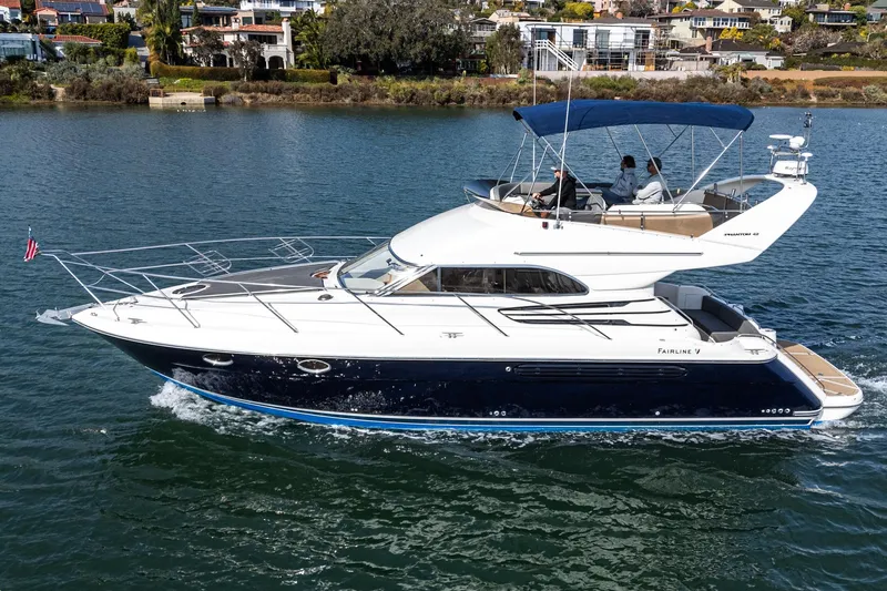 Phantom 42 Yacht Photos Pics 1998 Fairline Phantom 42 yacht cruising on a serene waterway, showcasing elegant design and luxury.