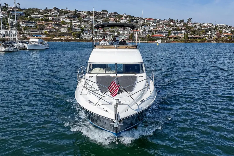 Phantom 42 Yacht Photos Pics 1998 Fairline Phantom 42 yacht cruising on a scenic waterfront with hillside homes.