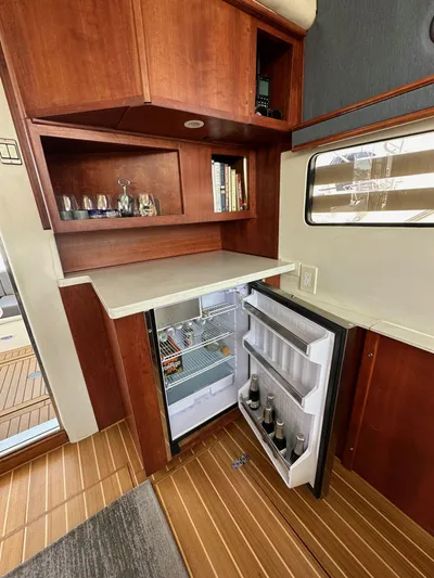 Phantom 42 Yacht Photos Pics Interior of 1998 Fairline Phantom 42 yacht with open fridge and wooden cabinetry.
