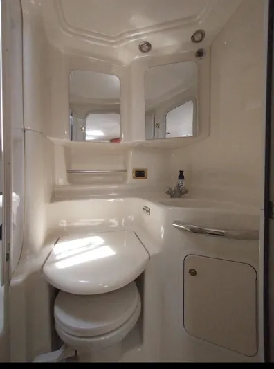 Cdog Yacht Photos Pics 2001 Sea Ray 380 Sundancer bathroom with white fixtures and mirrored cabinets.