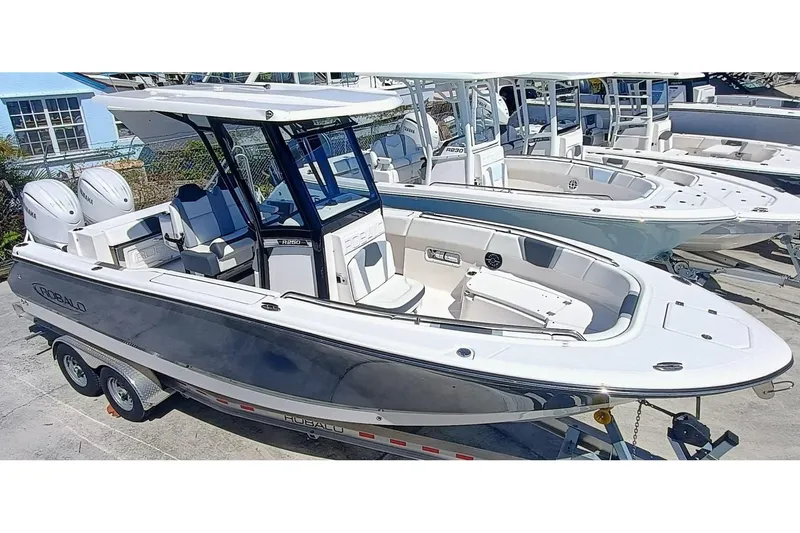 250-132 Yacht Photos Pics 2024 Robalo R250 Center Console boat on trailer, featuring sleek design and spacious deck.