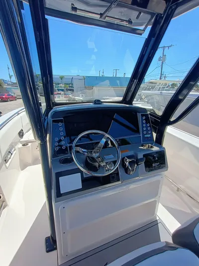 250-132 Yacht Photos Pics 2024 Robalo R250 Center Console boat dashboard with steering wheel and navigation controls.