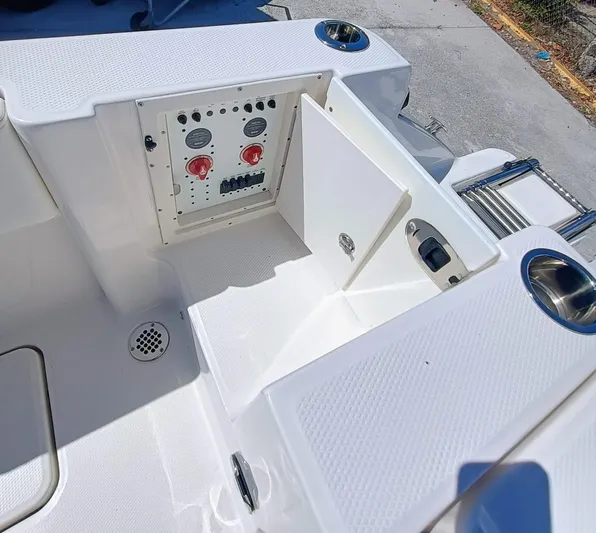 250-132 Yacht Photos Pics 2024 Robalo R250 Center Console boat with open storage compartment and control panel.