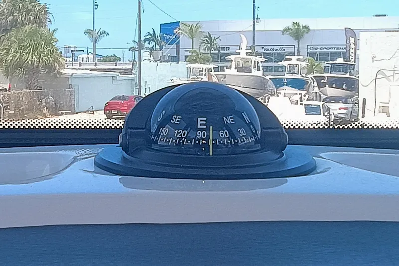 250-132 Yacht Photos Pics Compass on 2024 Robalo R250 Center Console boat, pointing east, with marina background.