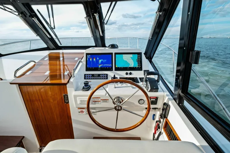  Yacht Photos Pics Helm of 2025 MJM 42 boat with navigation screens and wooden steering wheel.