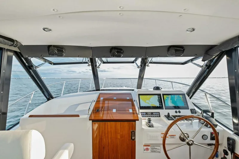  Yacht Photos Pics Helm of 2025 MJM 42 yacht with navigation screens and wooden steering wheel.