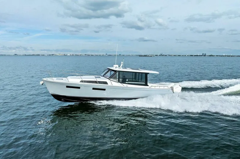  Yacht Photos Pics 2025 MJM 42 boat cruising on open water under a cloudy sky.