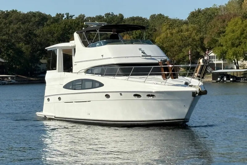  Yacht Photos Pics 2002 Carver 506 Motor Yacht cruising on a serene lake with lush green surroundings.