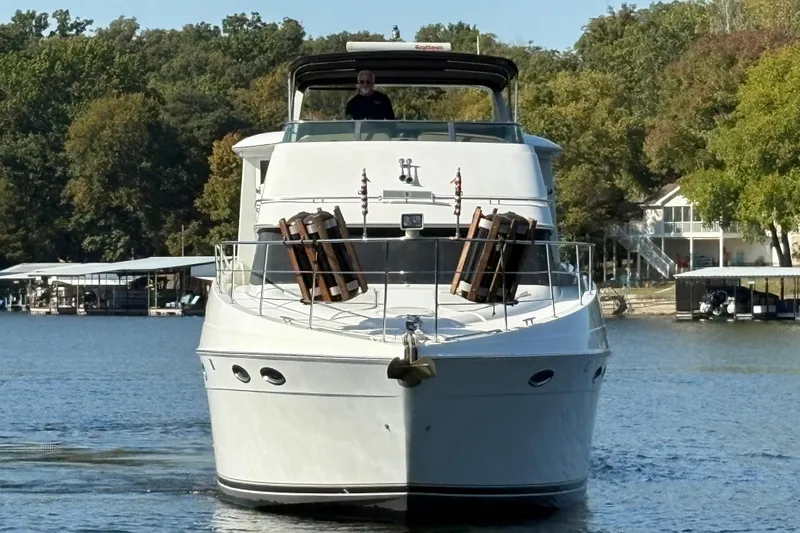  Yacht Photos Pics 2002 Carver 506 Motor Yacht cruising on a serene lake with lush green surroundings.