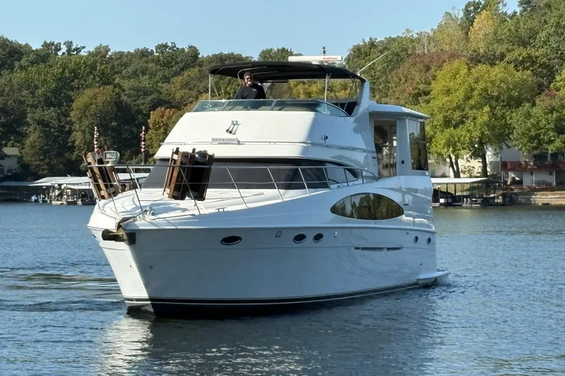  Yacht Photos Pics 2002 Carver 506 Motor Yacht cruising on a serene lake with lush green surroundings.