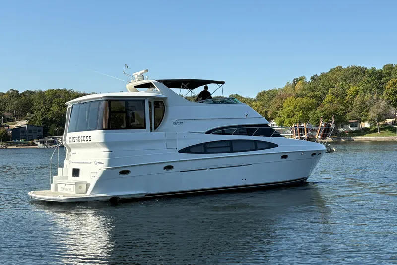  Yacht Photos Pics 2002 Carver 506 Motor Yacht on a serene lake with lush green shoreline.