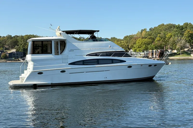  Yacht Photos Pics 2002 Carver 506 Motor Yacht on a serene lake with lush green shoreline.