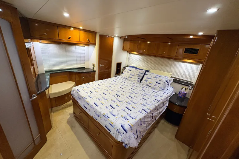  Yacht Photos Pics Luxurious bedroom interior of 2002 Carver 506 Motor Yacht with wood cabinetry and nautical bedding.