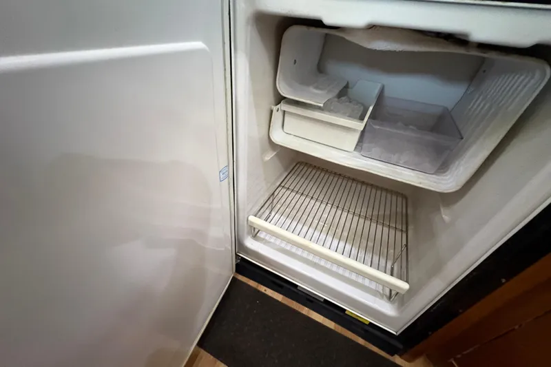  Yacht Photos Pics Open freezer compartment in 2002 Carver 506 Motor Yacht, showing empty shelves and ice tray.