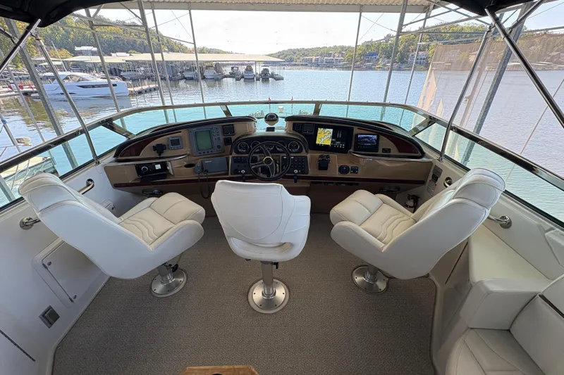  Yacht Photos Pics Helm of 2002 Carver 506 Motor Yacht with three white captain chairs and navigation equipment.