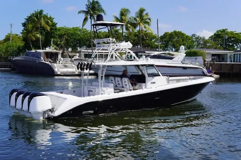  Yacht Photos Pics 2016 Everglades 435 Center Console boat on water, surrounded by yachts and palm trees.