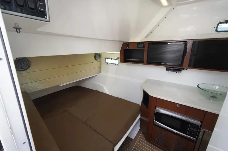  Yacht Photos Pics 2016 Everglades 435 Center Console cabin interior with bed, kitchenette, and storage.