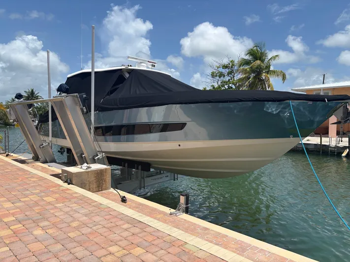 Demo Diamond Yacht Photos Pics 2017 Boston Whaler 420 Outrage on lift by waterfront, under clear sky.