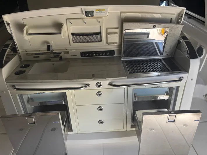 Demo Diamond Yacht Photos Pics 2017 Boston Whaler 420 Outrage boat kitchen with grill, sink, and storage compartments.