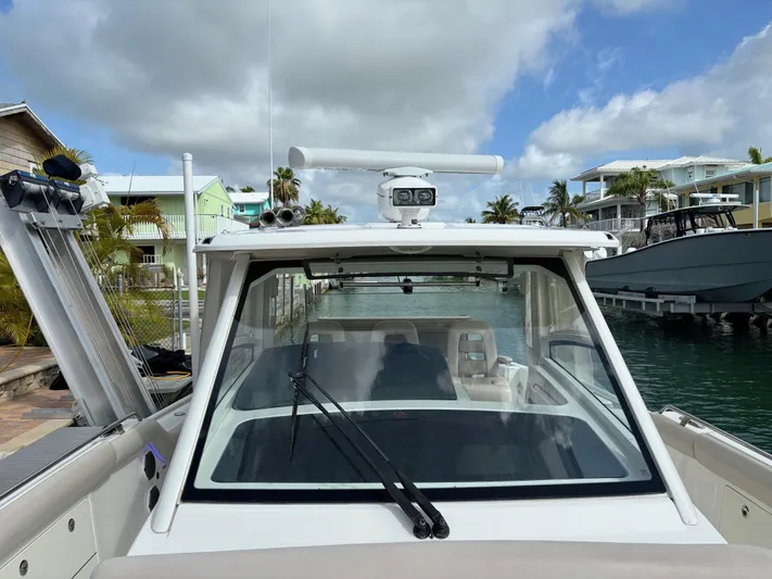 Demo Diamond Yacht Photos Pics 2017 Boston Whaler 420 Outrage boat docked, showcasing helm and windshield under cloudy sky.