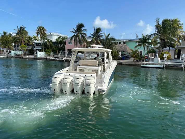 Demo Diamond Yacht Photos Pics 2017 Boston Whaler 420 Outrage cruising in tropical waters near palm-lined shore.
