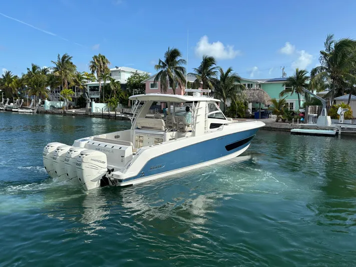 Demo Diamond Yacht Photos Pics 2017 Boston Whaler 420 Outrage boat cruising in tropical waters near palm trees.