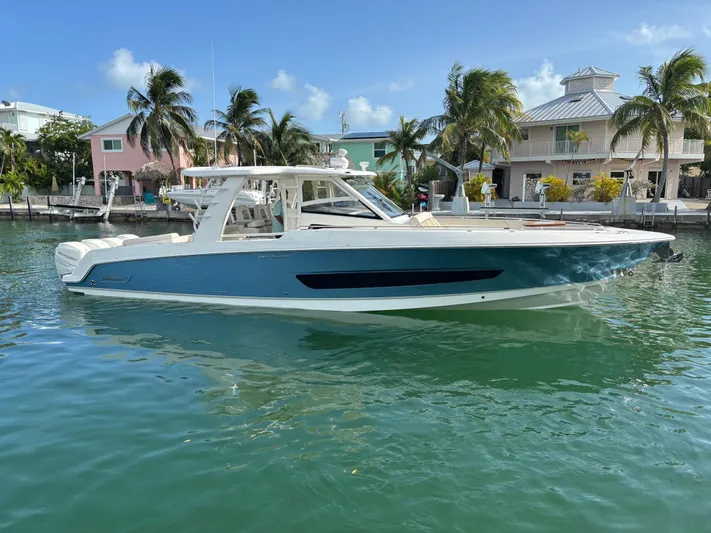 Demo Diamond Yacht Photos Pics 2017 Boston Whaler 420 Outrage boat docked near tropical waterfront homes.