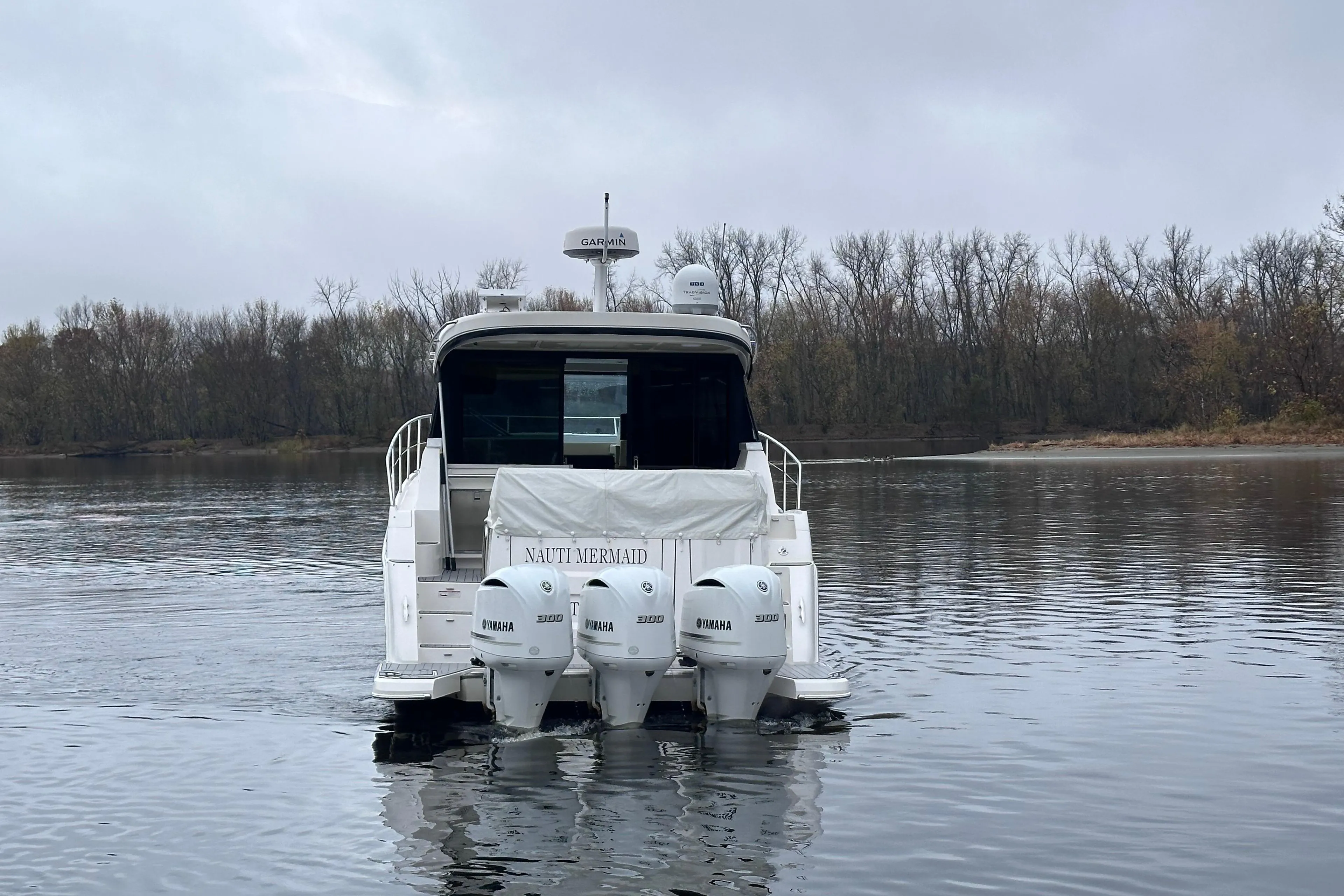 2021 Regal 38 XO boat with triple Yamaha engines on a calm lake.