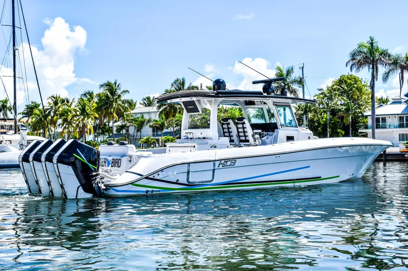 Water Bird Yacht Photos Pics 2025 HCB 42 Lujo boat on water, featuring multiple outboard engines, surrounded by palm trees.