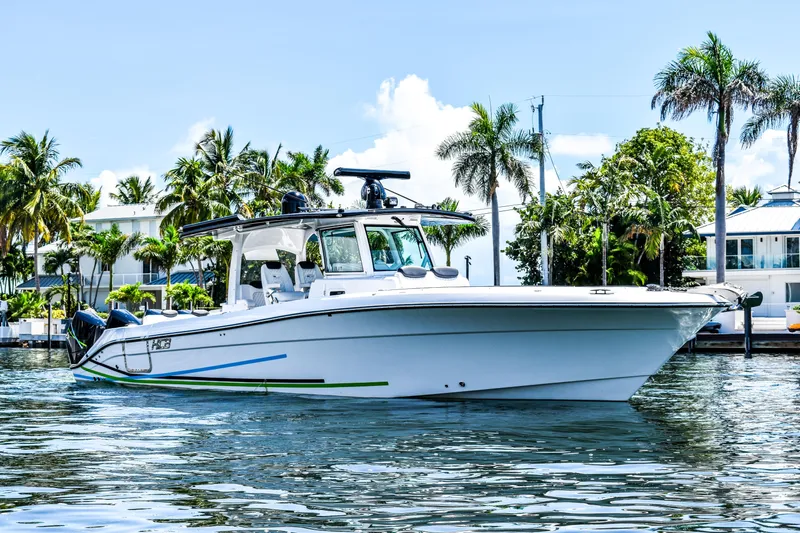 Water Bird Yacht Photos Pics 2025 HCB 42 Lujo boat on water, surrounded by palm trees and waterfront homes.