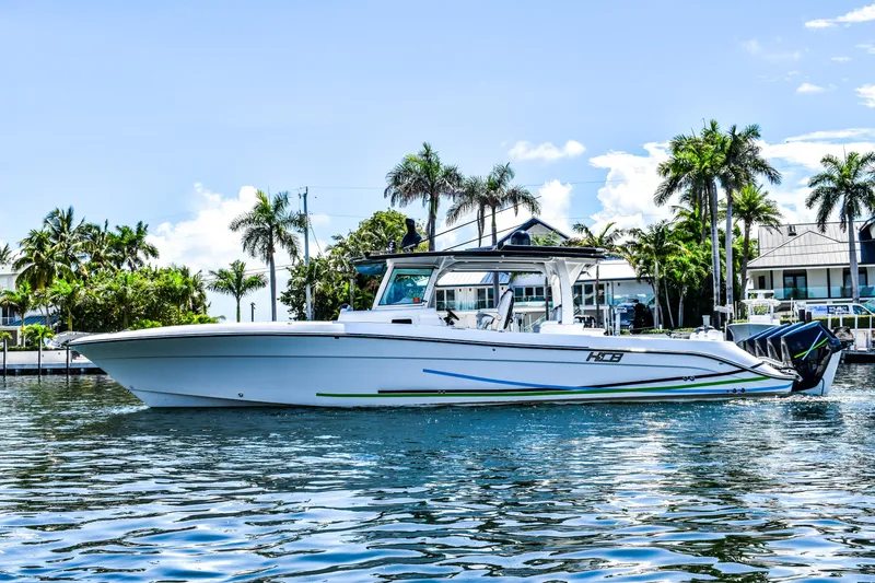 Water Bird Yacht Photos Pics 2025 HCB 42 Lujo boat on water, surrounded by palm trees and waterfront homes.