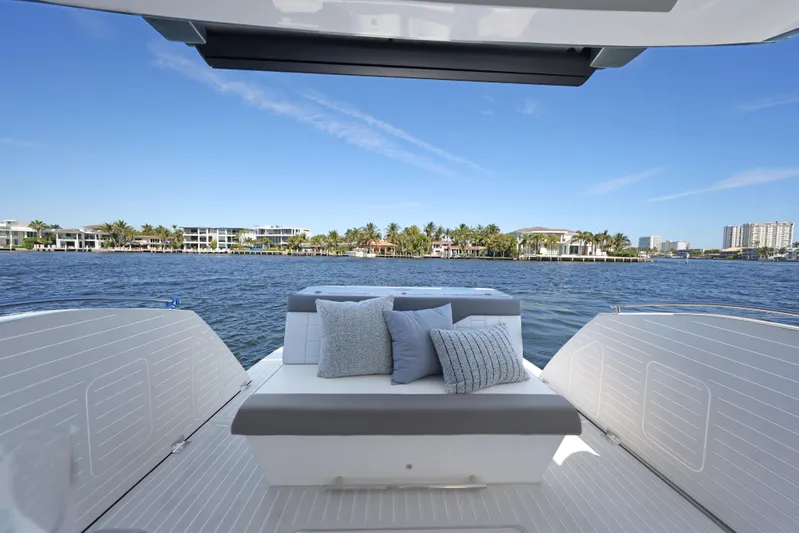  Yacht Photos Pics 2025 Valiatt 380 Bowrider boat interior with cushions, overlooking waterfront homes and clear blue sky.