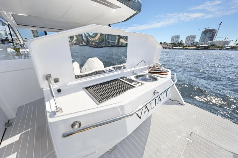 Yacht Photos Pics 2025 Valiatt 380 Bowrider boat with outdoor kitchen, docked by waterfront cityscape.
